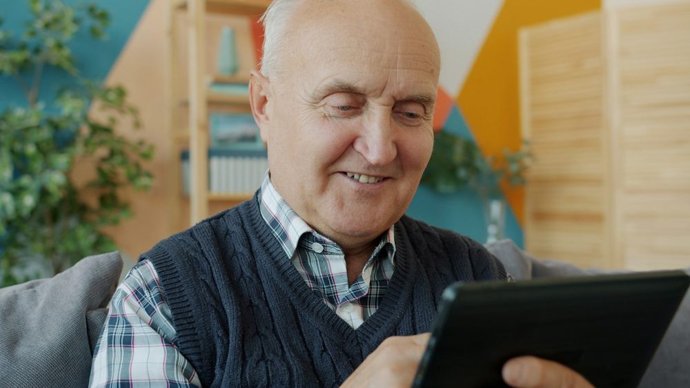 Homme senior utilisant une tablette avec aisance